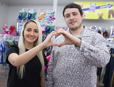 Two store team members make the heart gesture with their hands
