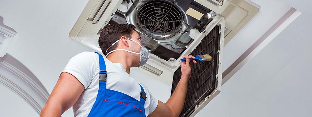 Man cleaning ventilation filter