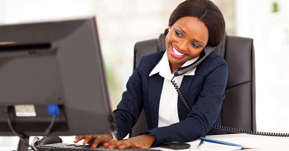 Woman on phone at computer workstation