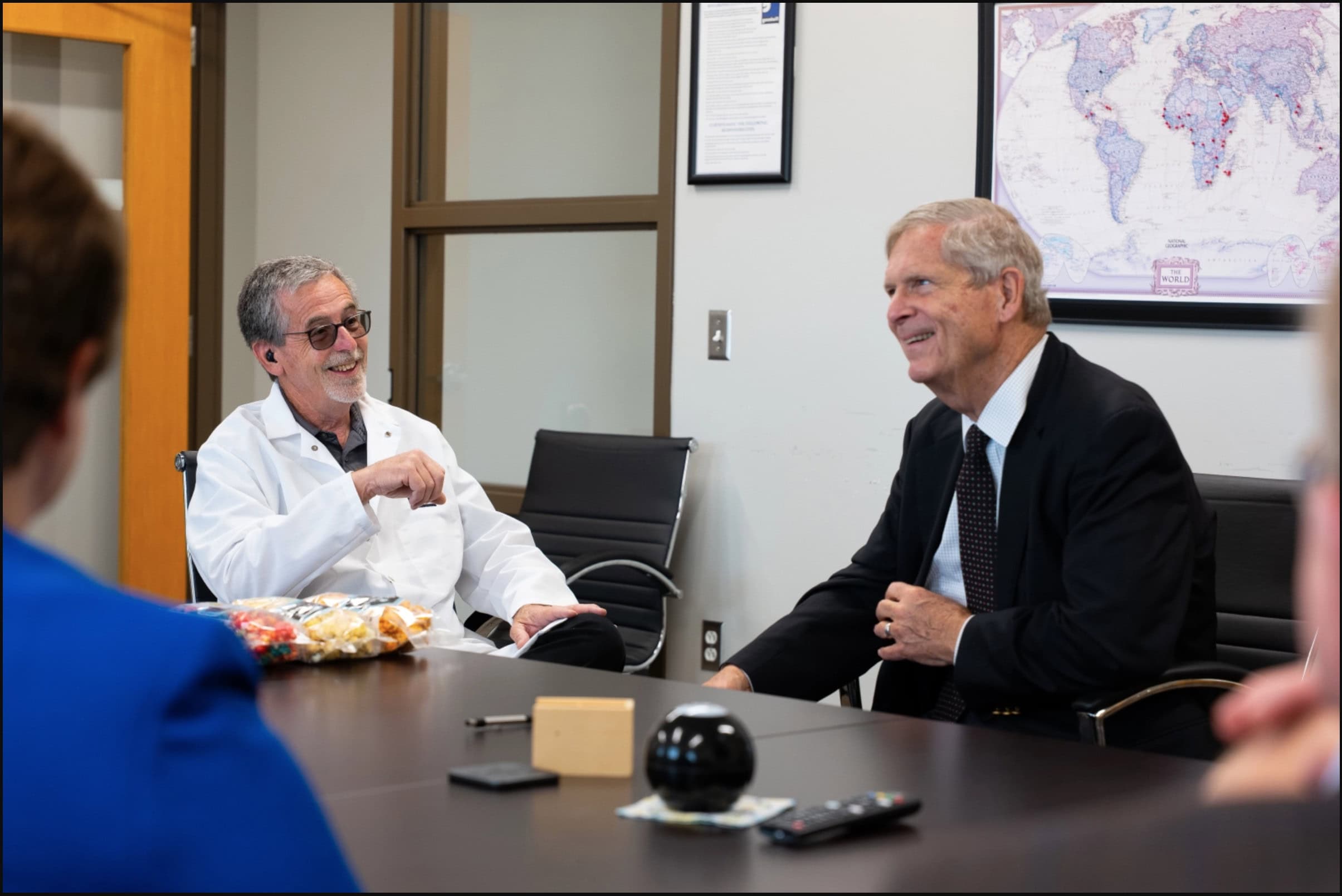Former Iowa Gov. and U.S. Secretary of Agriculture Tom Vilsack toured Goodwill's Oil Packaging Plant in Coralville during June 2026. In this photo, Vilsack speaks with Plant Director Spike Stabler and other officials during a stakeholder meeting.